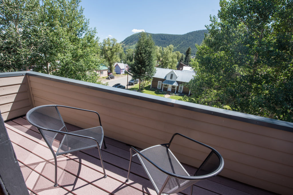 Guest room balcony overlooking downtown Crested Butte and the mountains at Elk Mountain Lodge