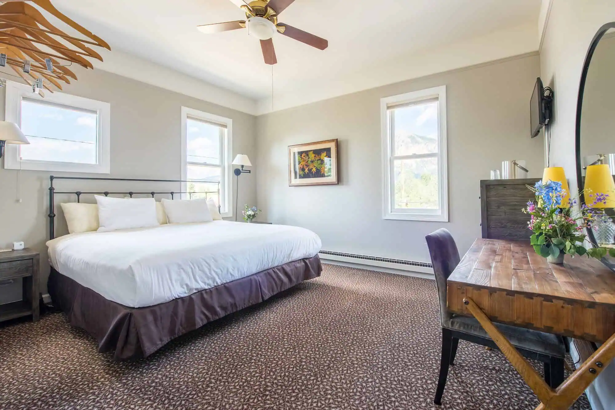 Guest room with queen bed and mountain-view windows at Elk Mountain Lodge in Crested Butte
