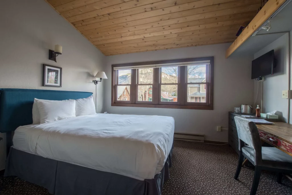 Third-floor king room with vaulted wood ceiling and mountain views at Elk Mountain Lodge, Crested Butte