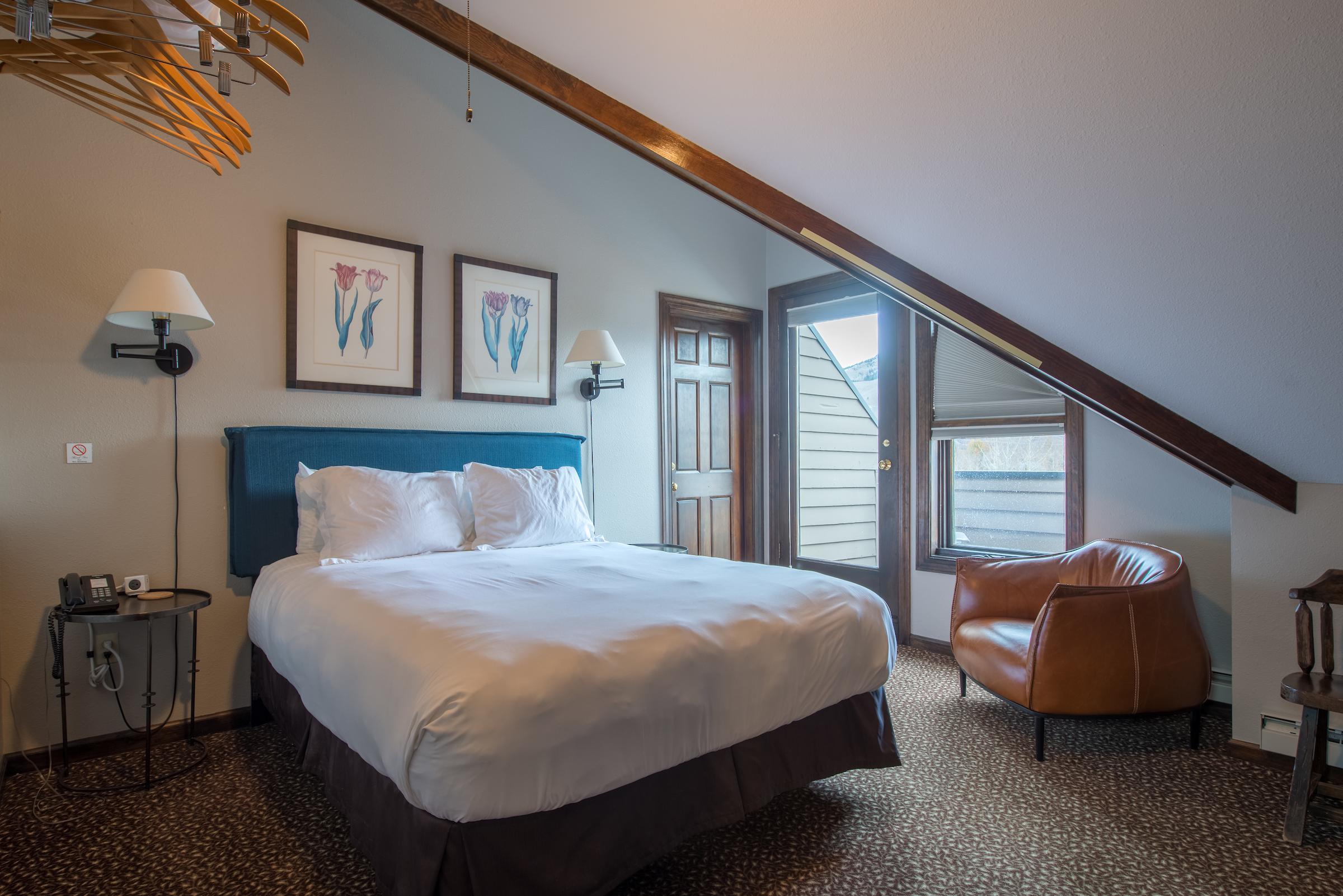 Third-floor king room with vaulted ceiling and private balcony door at Elk Mountain Lodge, Crested Butte